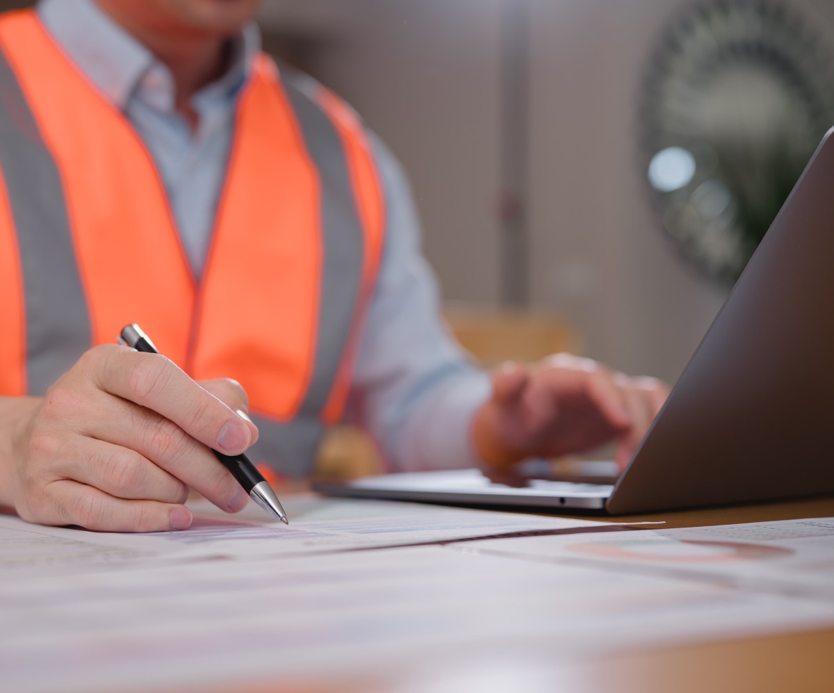 construction subcontractor working on financial documents and computer,